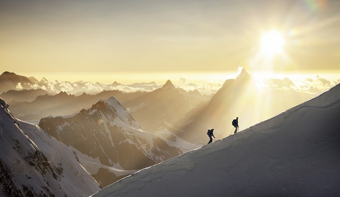 Mountain climbers on peak at sunrise